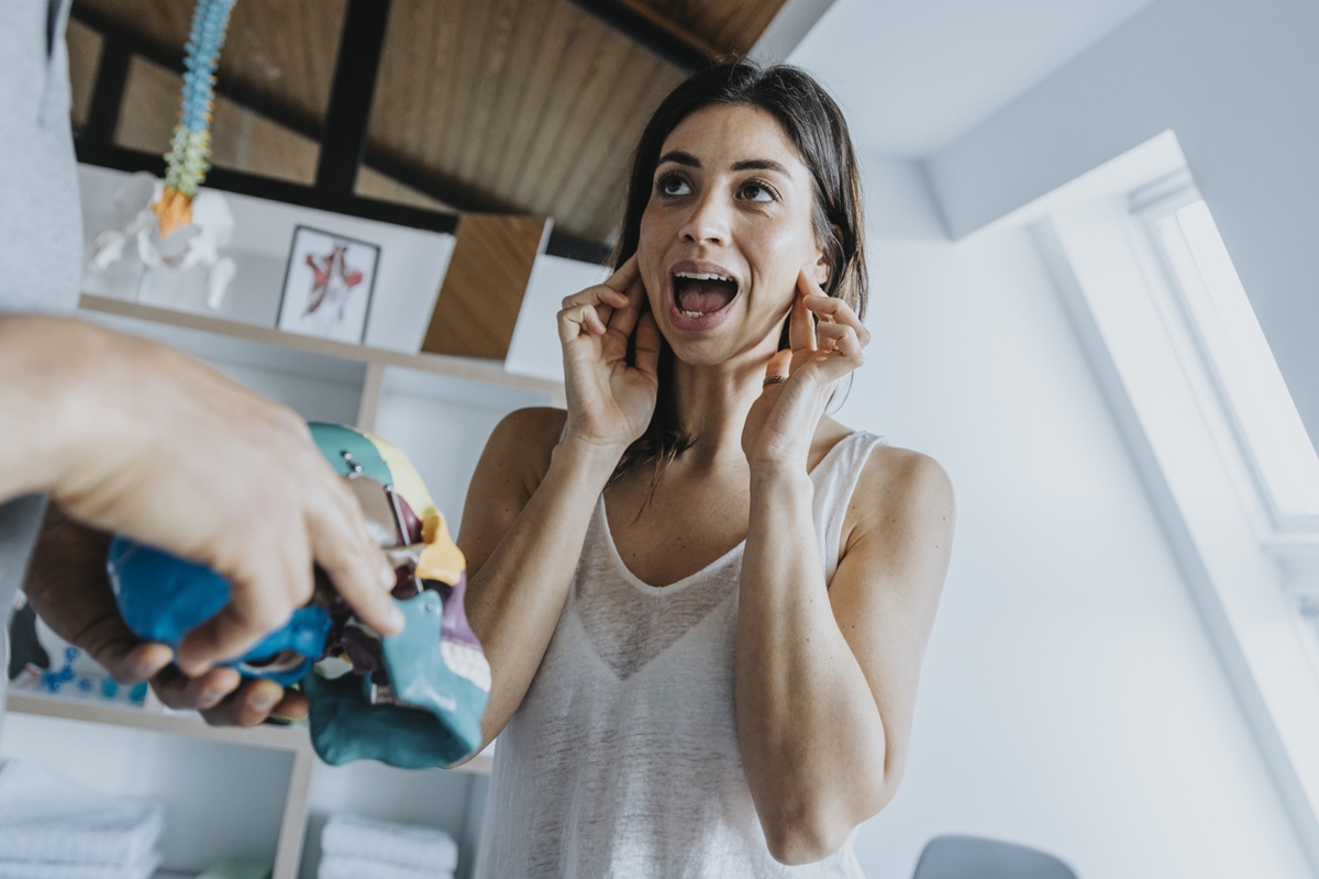 Female patient discussing with male physical therapist about jaw and bruxism in practice