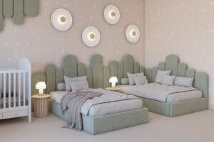 A imagem apresenta um quarto infantil com duas camas verdes acolchoadas e um berço branco. As paredes têm papel decorativo bege com detalhes sutis e luminárias modernas. Dicas de decoração para quem tem TDAH incluem cores suaves e organização funcional.